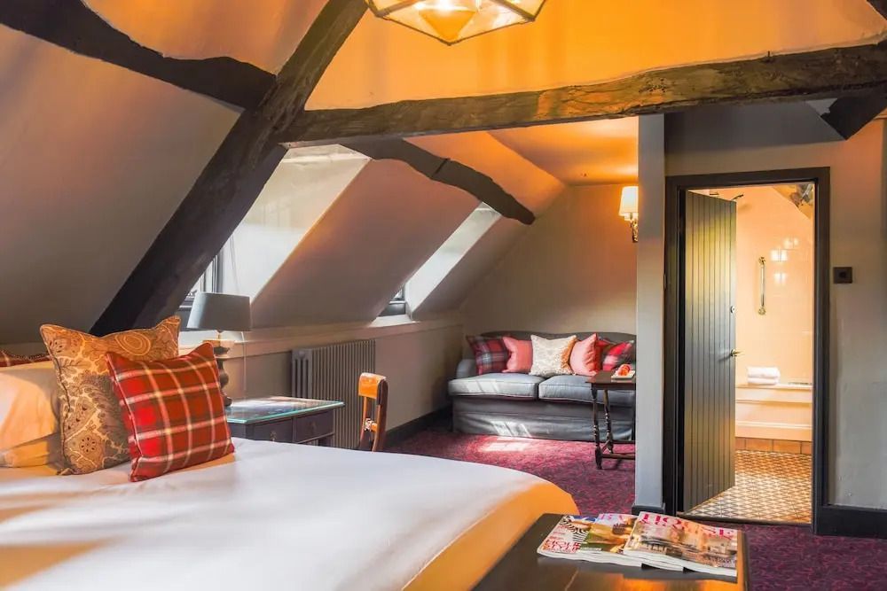 Charmantes Superior Doppelzimmer mit rustikalen Holzbalken und gemütlicher Sofaecke