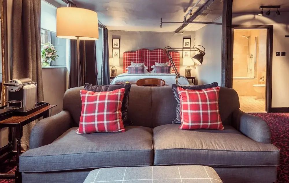 Gemütlicher Wohnbereich mit Sofa und karierten Kissen im Superior Doppelzimmer