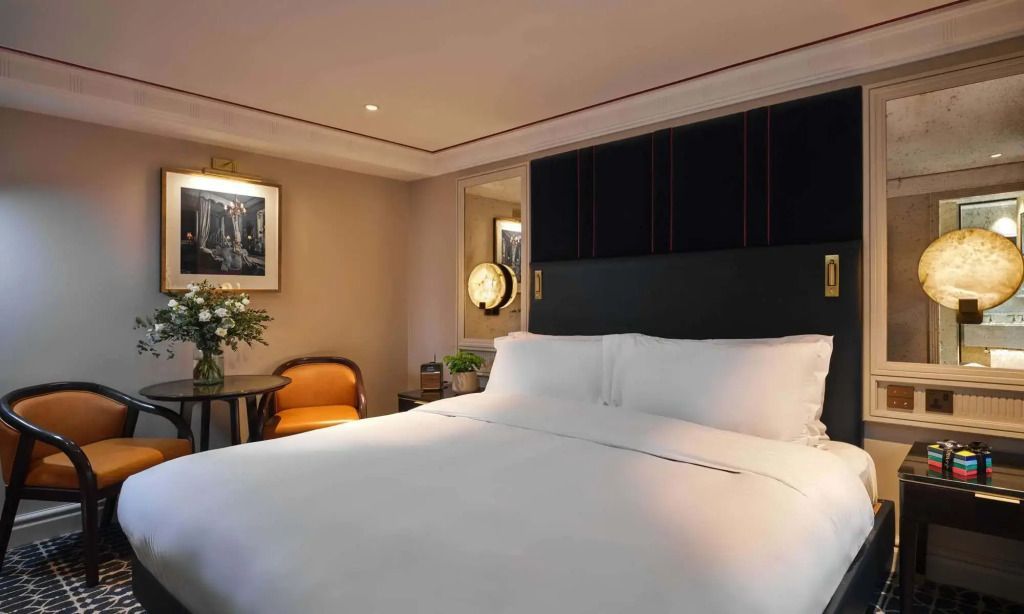 Elegantes Hotelzimmer mit großem Doppelbett und stilvoller Beleuchtung.