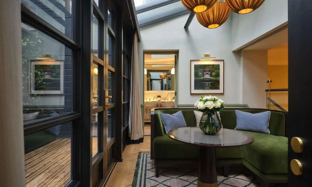 Heller Sitzbereich in der Garden Suite mit stilvollem Tisch und Blumenarrangement
