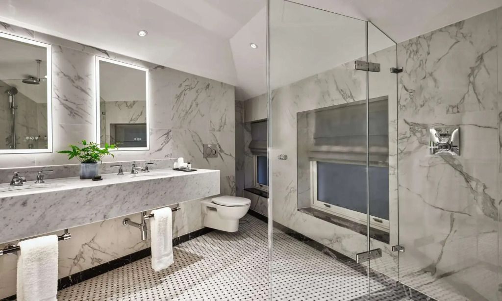 Modernes Badezimmer mit Marmoroberflächen und Glasdusche