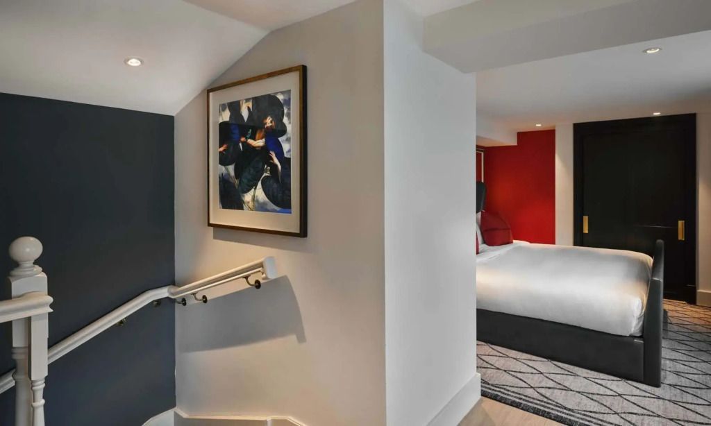 Flur mit Kunstwerken führt zu einem modernen Schlafzimmer in der Suite