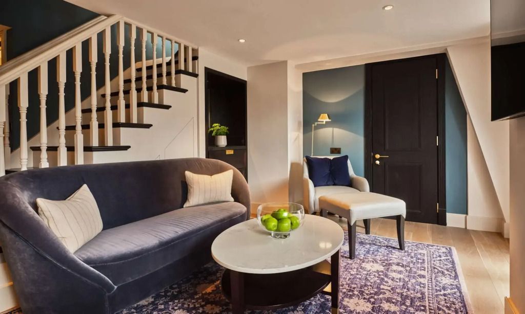 Gemütliche Sitzecke mit luxuriösem Sofa und Obstschale in der Suite