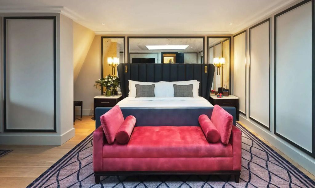 Elegantes Schlafzimmer mit großem Doppelbett und stilvollem rotem Sofa
