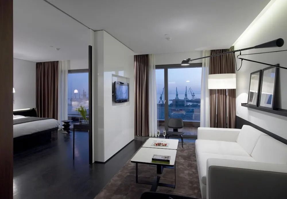 Geräumiges Wohnzimmer der Suite mit Sofa, Fernseher und Hafenblick