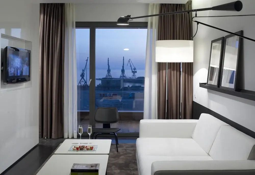 Wohnbereich mit Glasfront und Hafenansicht in der Suite