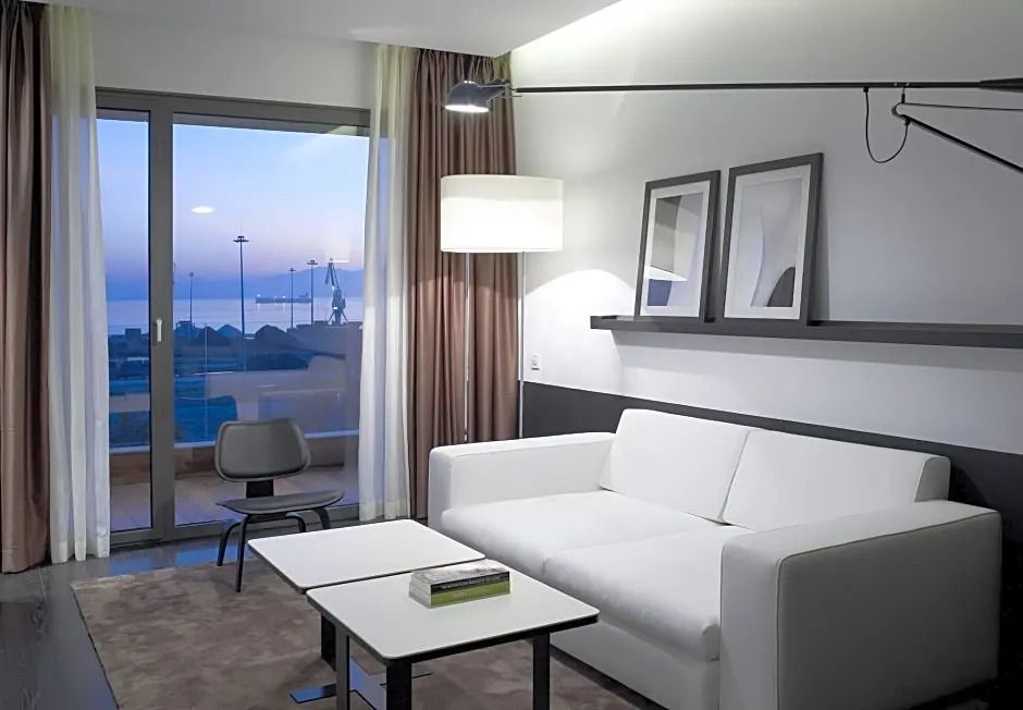 Moderne Sitzecke und Meerblick durch große Fensterfront in der Suite