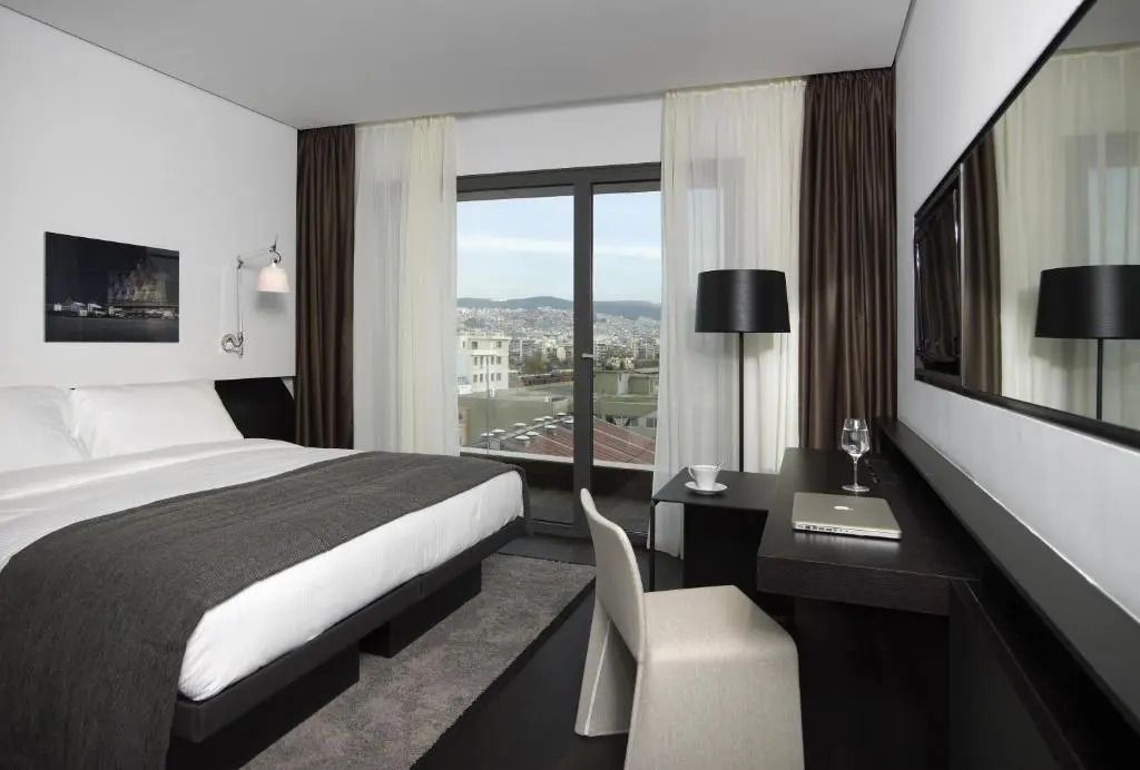 Modernes Executive Doppelzimmer mit großem Fenster und Blick auf die Stadt