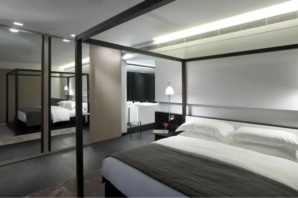 Modernes Schlafzimmer mit Himmelbett und Spiegelwand in der Met Suite