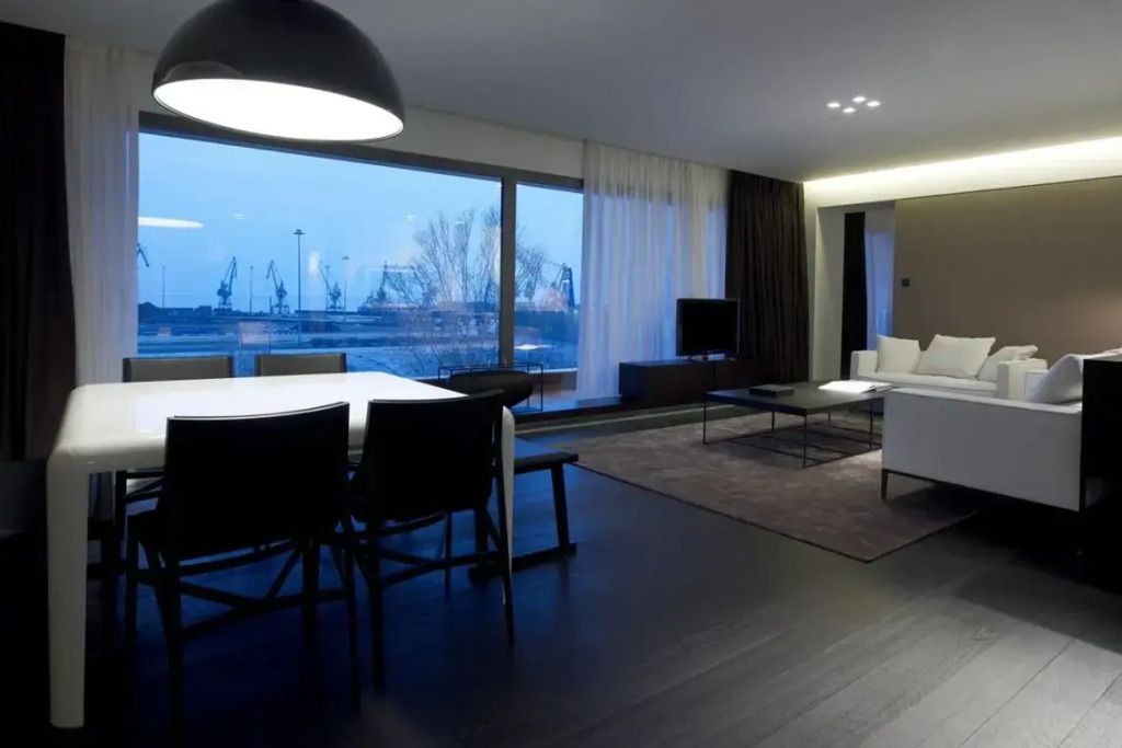 Wohnzimmer mit Glaswand und Blick aufs Wasser in der Met Suite