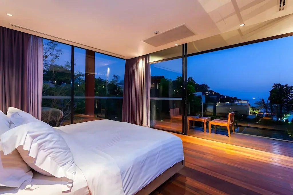 Schlafzimmer bei Nacht mit Aussicht auf beleuchtete Landschaft