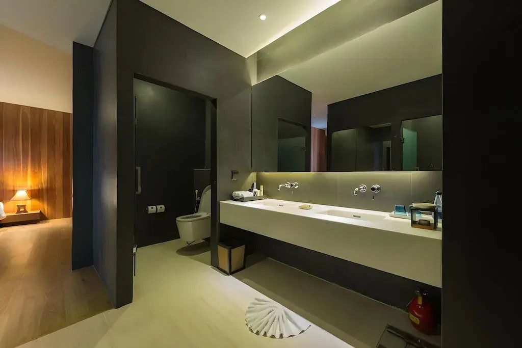 Elegantes Badezimmer mit Doppelwaschbecken, großer Spiegel und stilvolle Beleuchtung.