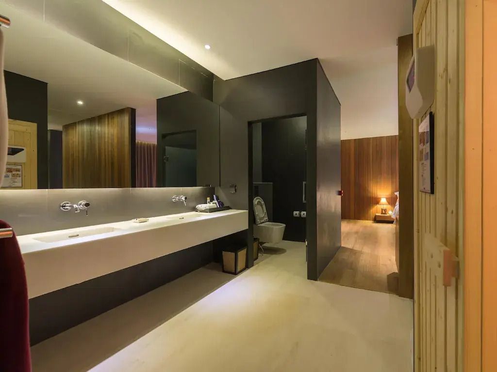 Modernes Badezimmer mit beleuchtetem Spiegel, Doppelwaschbecken und stilvollem Interieur.