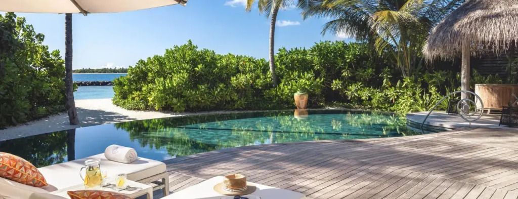 Privater Pool mit Sonnenliegen und tropischem Gartenblick