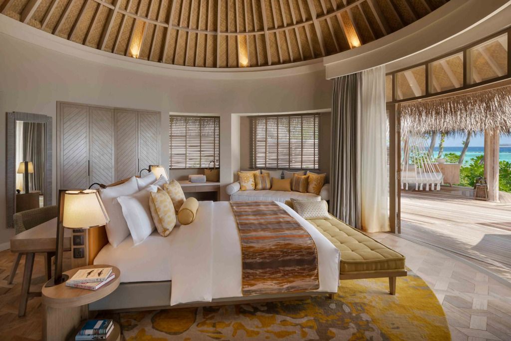 Elegant eingerichtetes Schlafzimmer mit Sitzbereich und Zugang zur Terrasse.