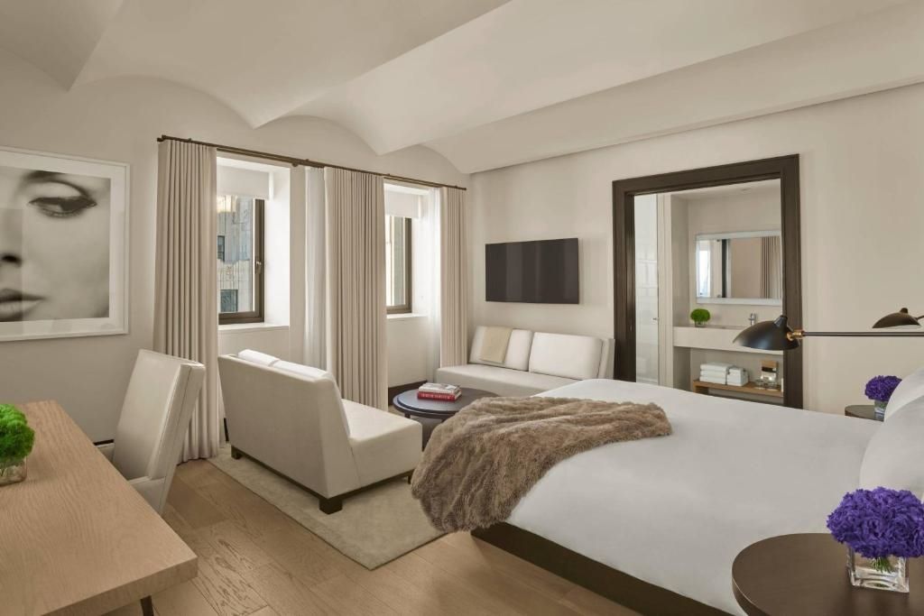 Helles Schlafzimmer mit Doppelbett, Sofa und natürlichen Holzböden