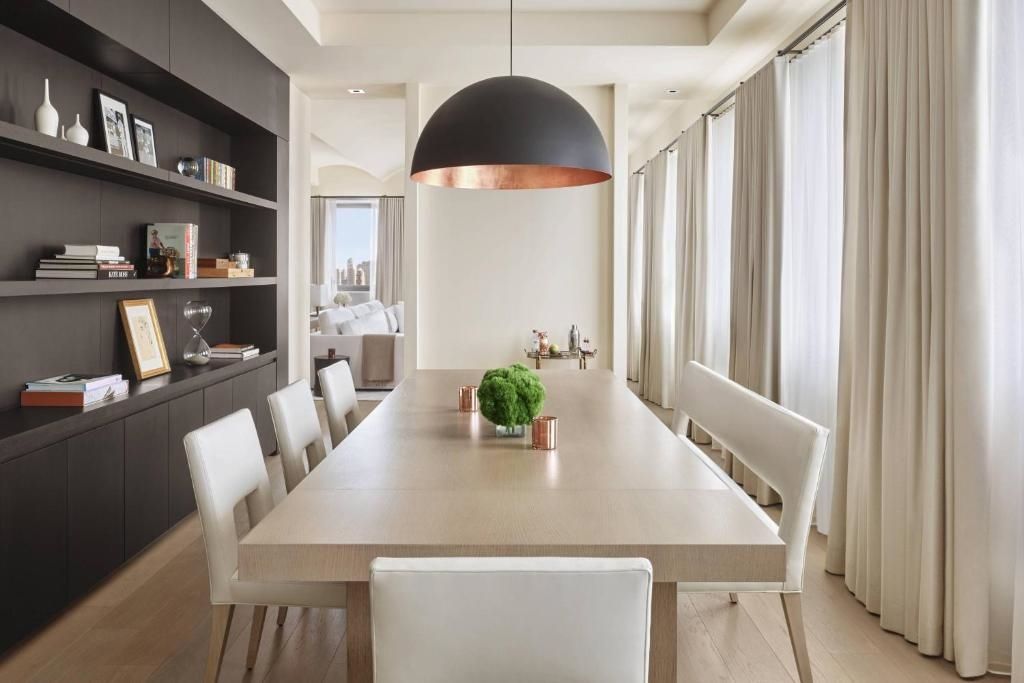 Moderner Essbereich mit großem Tisch und Designer-Lampe