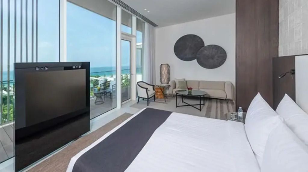 Helles Zimmer mit Meerblick, Doppelbett und modernem Sofa im Al Zorah Beach Resort