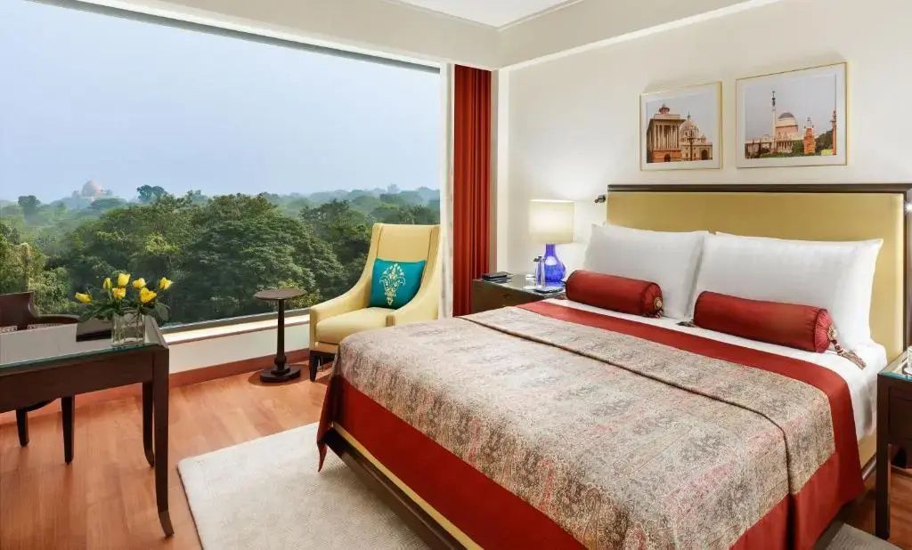 Elegantes Deluxe Doppelzimmer mit großem Fenster und Blick auf Bäume