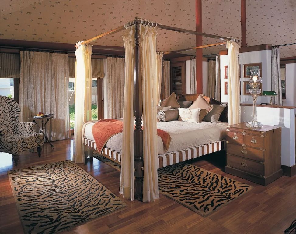 Helles Schlafzimmer mit Himmelbett und Naturmotiven