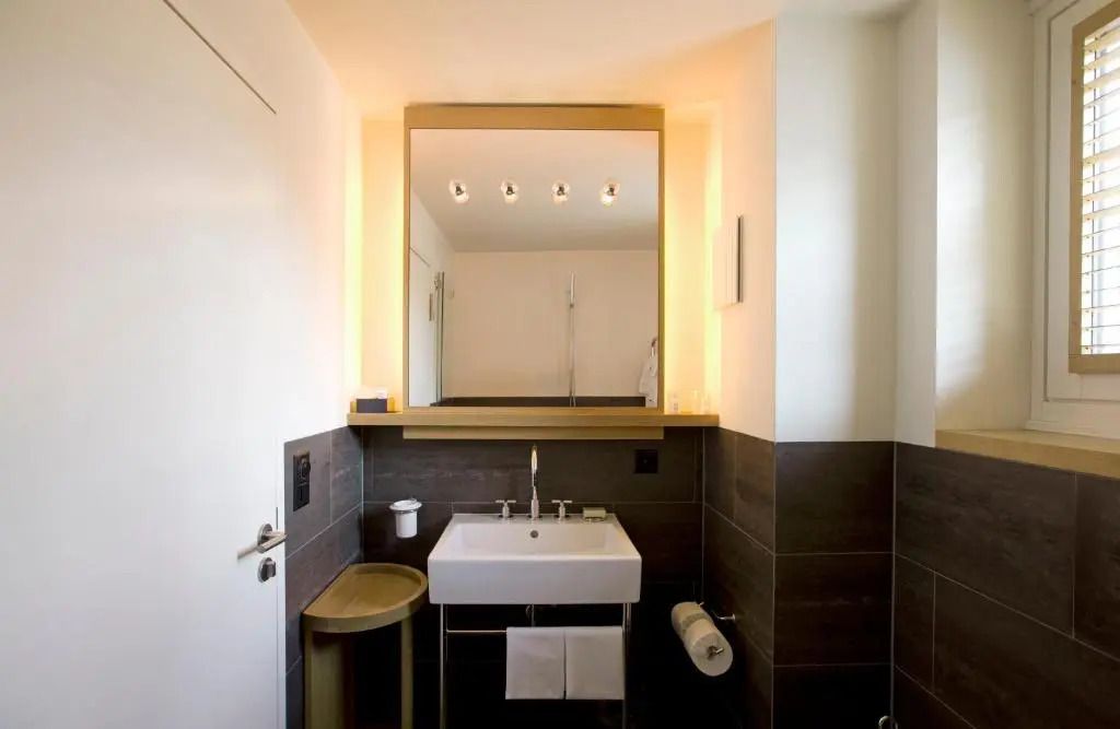 Modernes Badezimmer mit großem Spiegel und eleganter Beleuchtung
