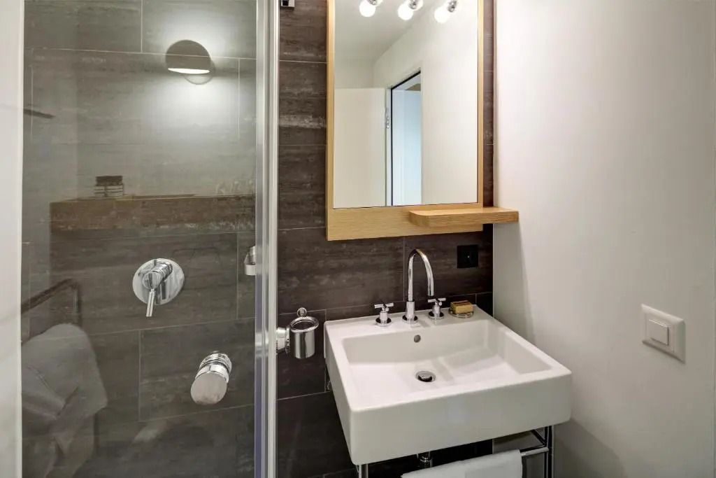 Modernes Bad mit Dusche und Waschbecken im Hotel