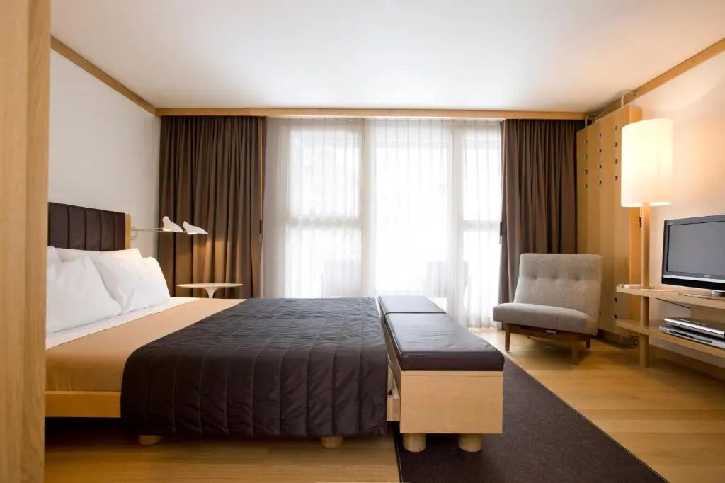Helles Doppelzimmer mit großen Fenstern und modernen Möbeln