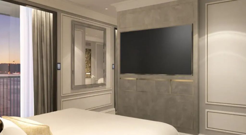 Elegantes Schlafzimmer einer Suite mit großem TV und Spiegel.
