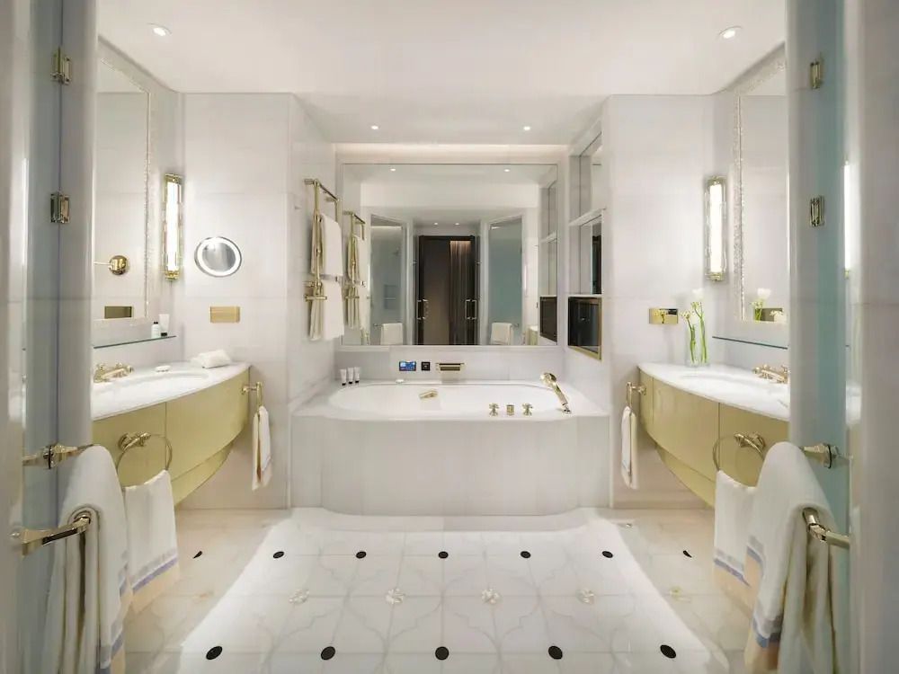 Luxuriöses Badezimmer in der Executive Doppel Suite mit goldenen Akzenten und großer Badewanne