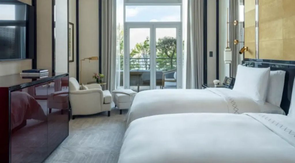 Doppelbettzimmer mit zwei Einzelbetten und Balkonzugang