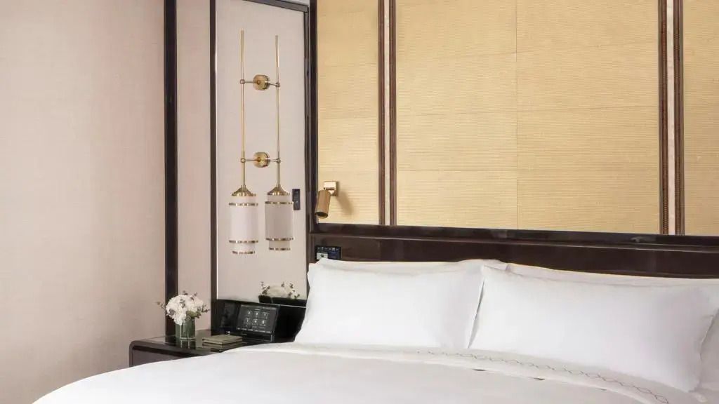 Nahaufnahme eines Doppelbetts in einem stilvoll eingerichteten Hotelzimmer