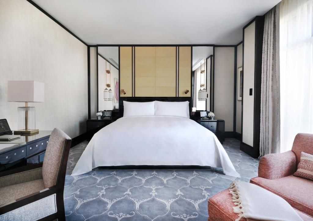 Helles Schlafzimmer mit einem großen Doppelbett in luxuriöser Hotel-Suite