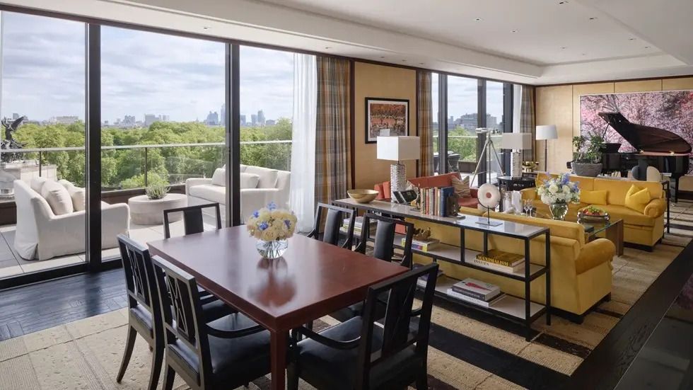 Wohnzimmer der Belgravia Suite mit großem Tisch und Zugang zum Balkon