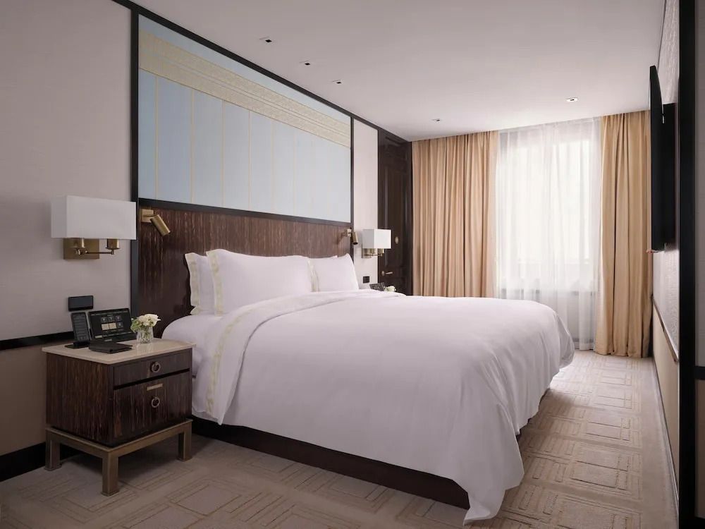 Deluxe Doppel Suite mit großem Doppelbett und eleganten Vorhängen
