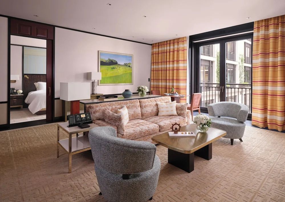 Wohnbereich der Deluxe Suite mit bequemen Sitzmöbeln und Balkonblick