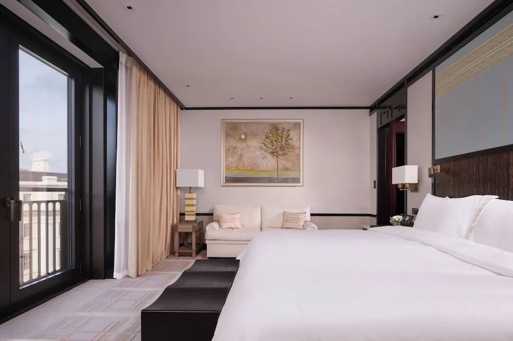 Stilvoll eingerichtetes Hotelzimmer mit Doppelbett und Kunstwerk an der Wand