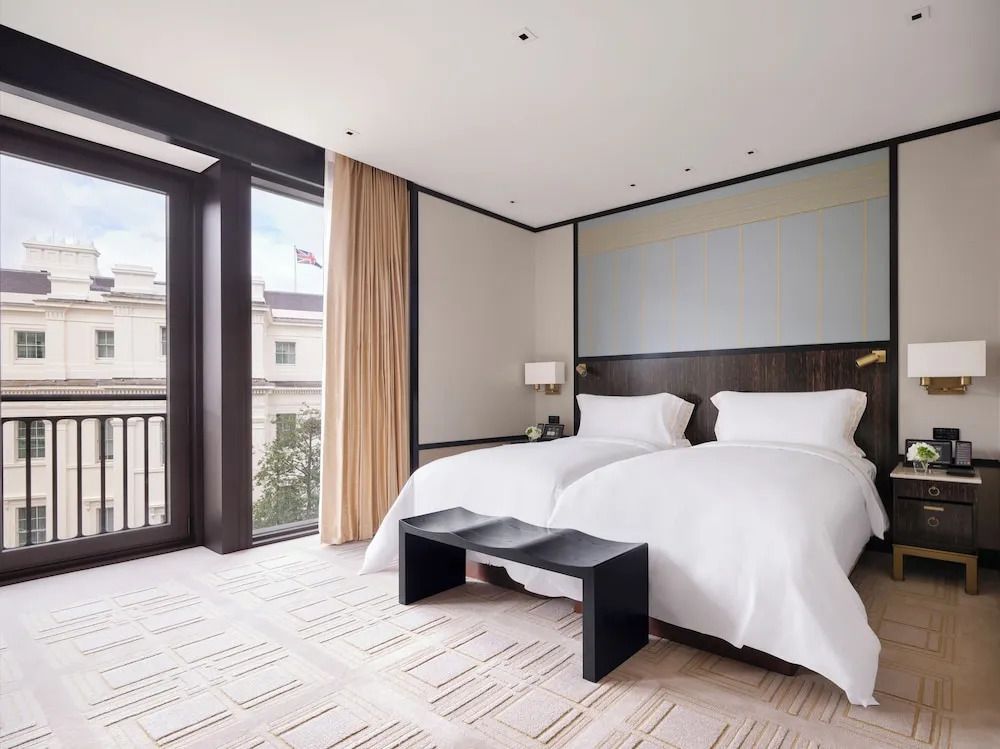 Hotelzimmer mit zwei Einzelbetten und Balkon, harmonisch eingerichtet.