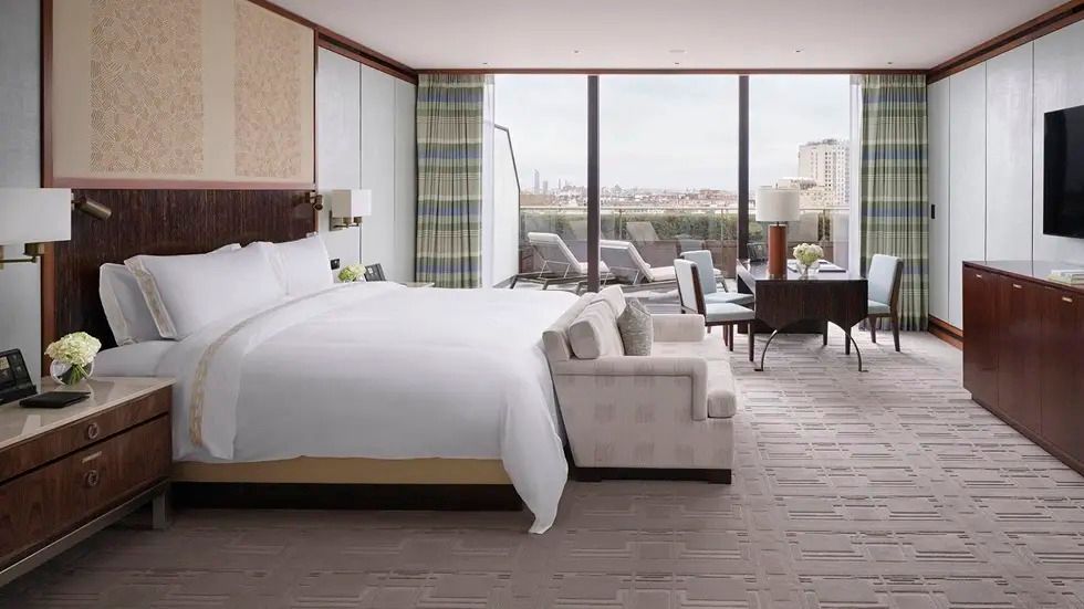 Helles Schlafzimmer mit großem Bett und Zugang zur Terrasse in der Grand Terrace Suite
