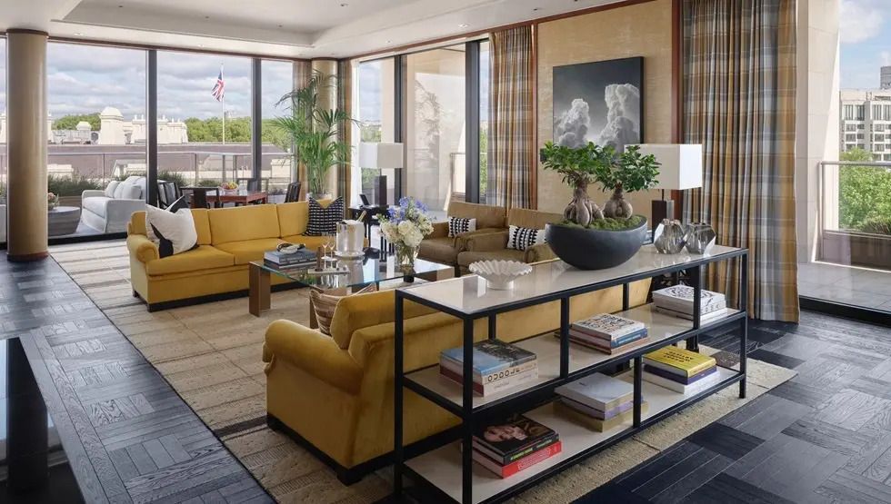 Luxuriöses Wohnzimmer der Peninsula Suite mit gelben Sofas und großen Fenstern