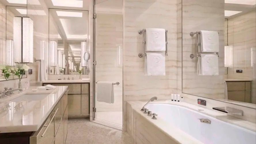 Helles Badezimmer aus Marmor mit Badewanne und Spiegeln