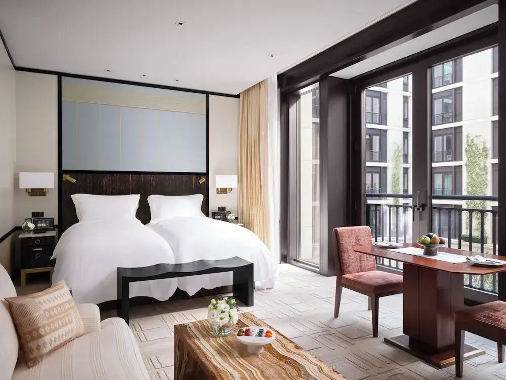 Modernes Zimmer mit Einzelbetten, großem Fenster und stilvollem Interieur