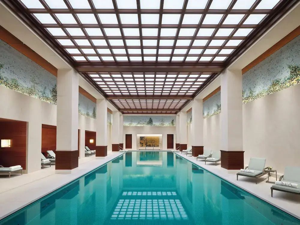 Indoor-Pool mit Glasdach und eleganten Liegen an den Seiten