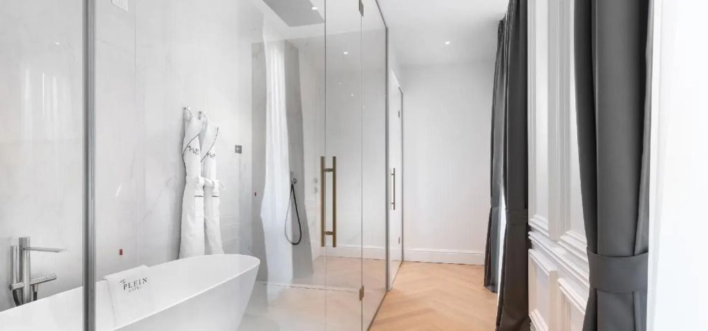 Moderne Dusche und Badbereich mit Glaswänden und minimalistischer Einrichtung