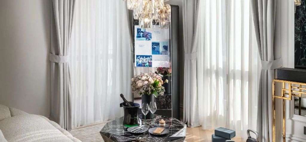 Eleganter Sitzbereich in der Suite mit Blumenstrauß und Champagner auf dem Tisch.