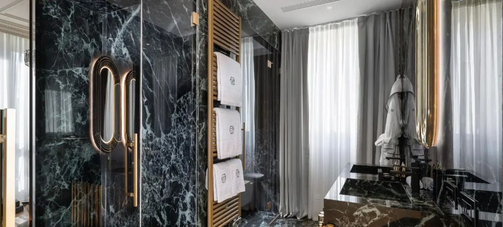 Modernes Badezimmer mit Marmorfliesen und eleganten Handtuchhaltern.