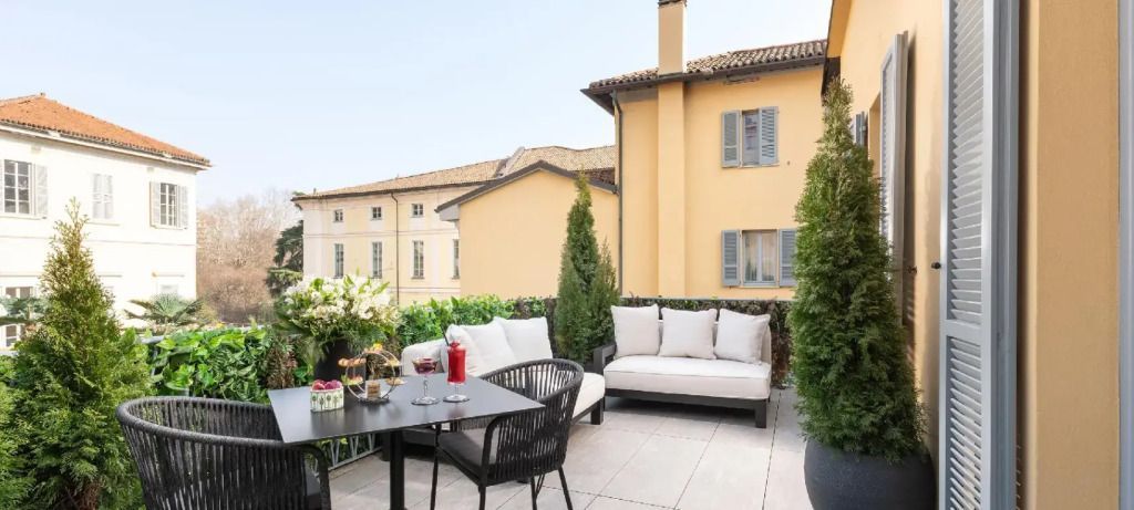 Private Terrasse mit Sitzgelegenheiten und Blick auf historische Gebäude
