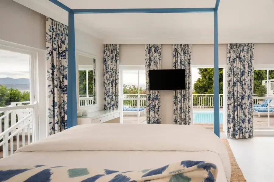 Elegantes Zimmer mit Himmelbett und Blick auf den Pool