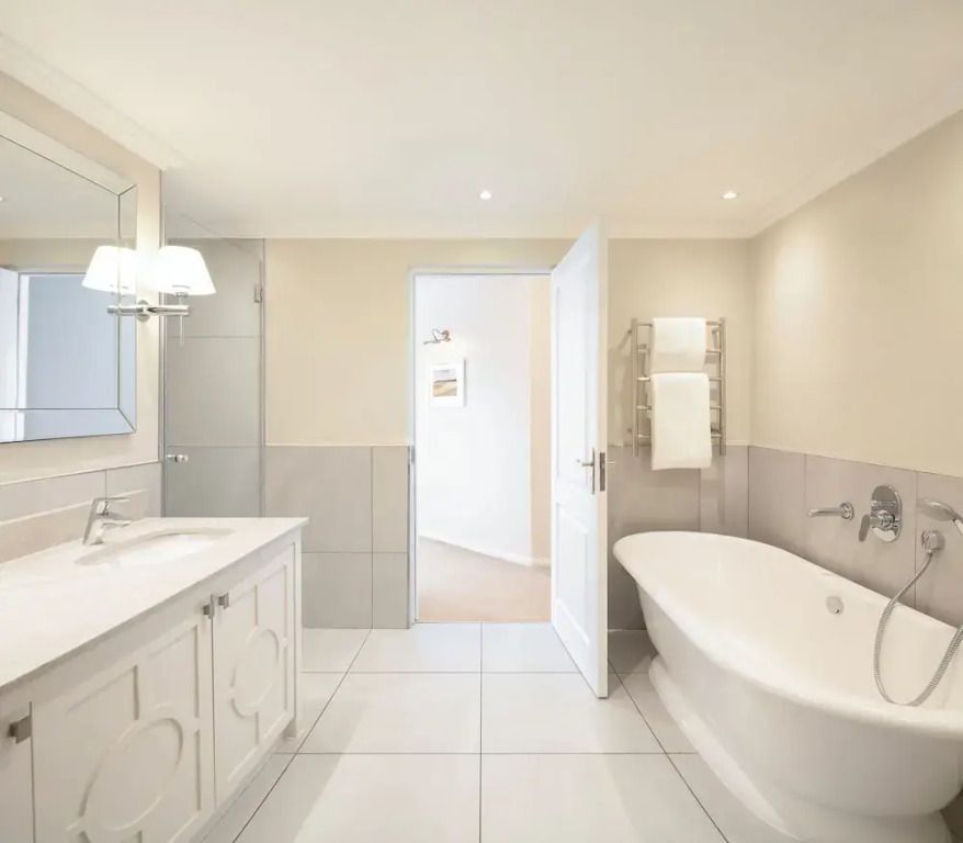 Helles Luxusbad mit freistehender Badewanne und eleganter Dekoration.