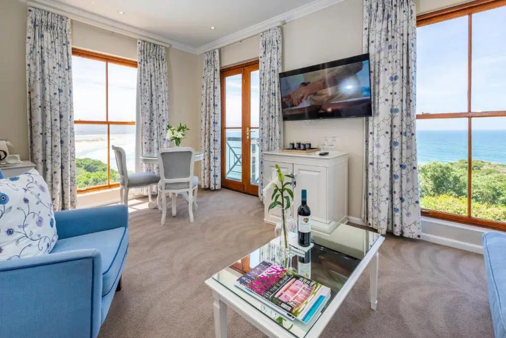 Modernes Wohnzimmer mit großem TV und Panoramablick in der Premier Suite