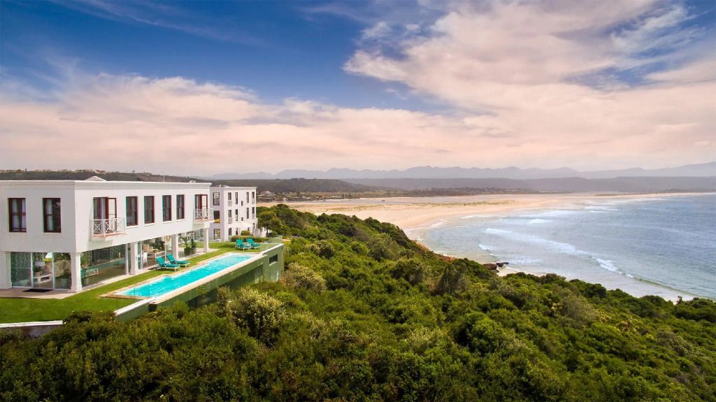Luxuriöses Hotel mit Infinity-Pool und Blick auf den Strand und die Küstenlandschaft.